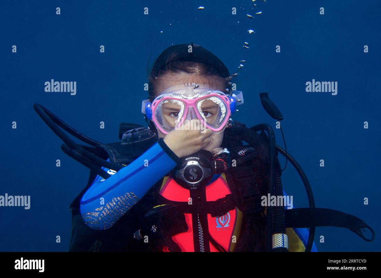 Equalizzazione ragazza subacquea di 9 anni, sito di immersione di Ghost Bay, Amed, Karangasem Regency, Bali, Indonesia, Oceano Indiano Foto Stock
