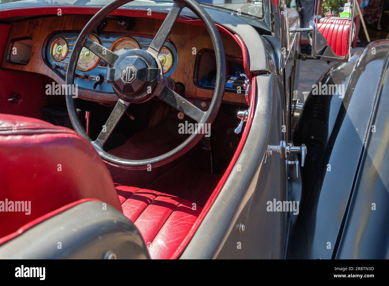 L'interno di una MG va anni '1930, con il logo MG, il cruscotto, il volante e i sedili in pelle rossa. Un'auto britannica ad una mostra d'auto d'epoca e d'epoca. Foto Stock