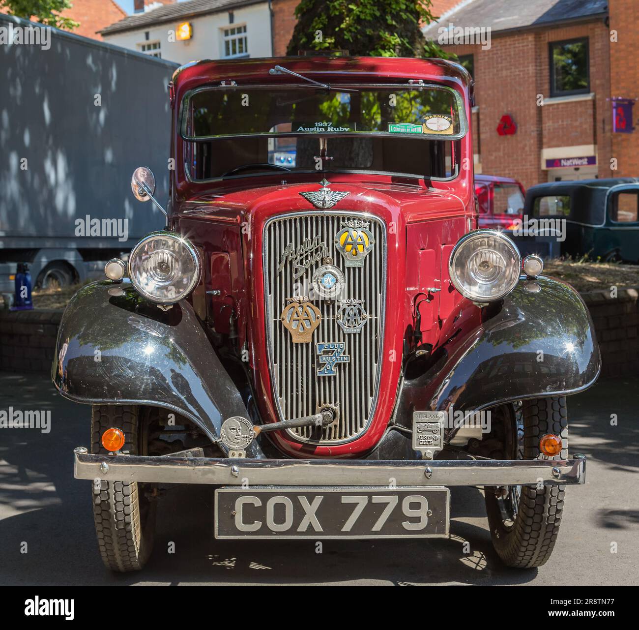 Vista frontale di una Austin Seven rossa degli anni '1930 con una maniglia di avviamento che sporge dalla griglia del radiatore. Austin Ruby ad una mostra d'auto d'epoca. Foto Stock