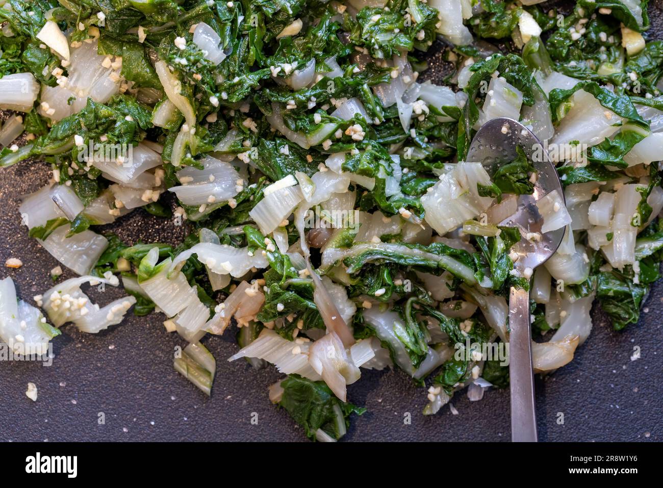 Swiss Chard appena cucinato tagliato insieme all'aglio sminuzzato Foto Stock