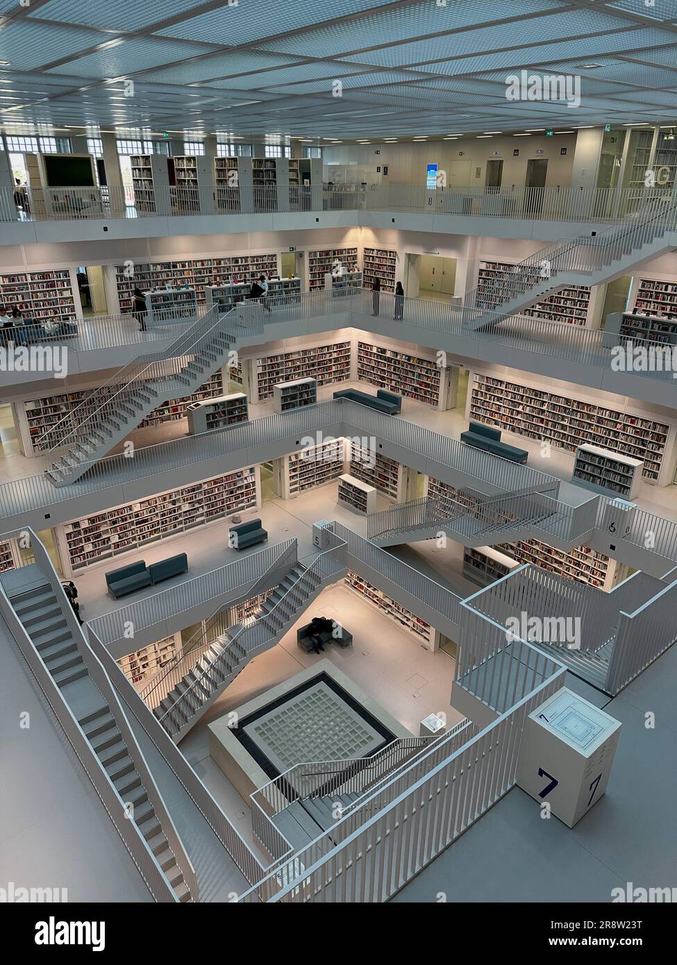 Vista in alto di una biblioteca ben fornita con una vasta collezione di libri e diverse persone che visitano gli scaffali Foto Stock