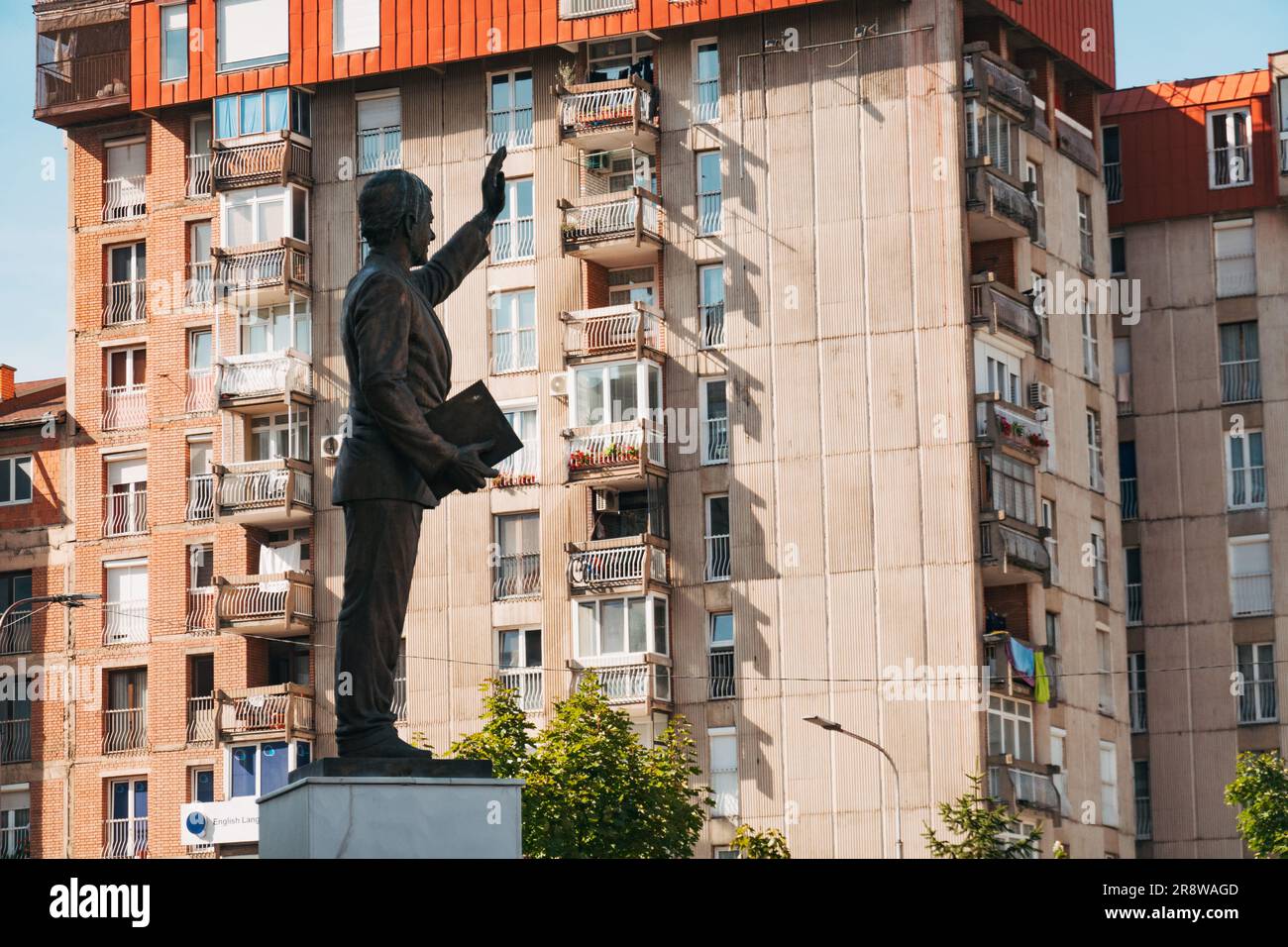 Una statua di U.S. Il presidente Bill Clinton contro i blocchi di appartamenti in cemento a Pristina, in Kosovo Foto Stock