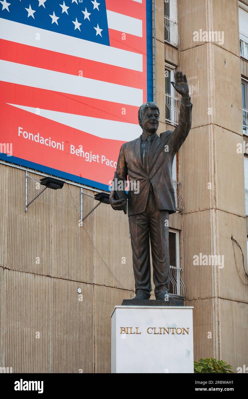 Una statua di U.S. Il presidente Bill Clinton eresse nel 2009 su un piedistallo davanti a un cartellone con bandiera americana a Pristina, in Kosovo Foto Stock