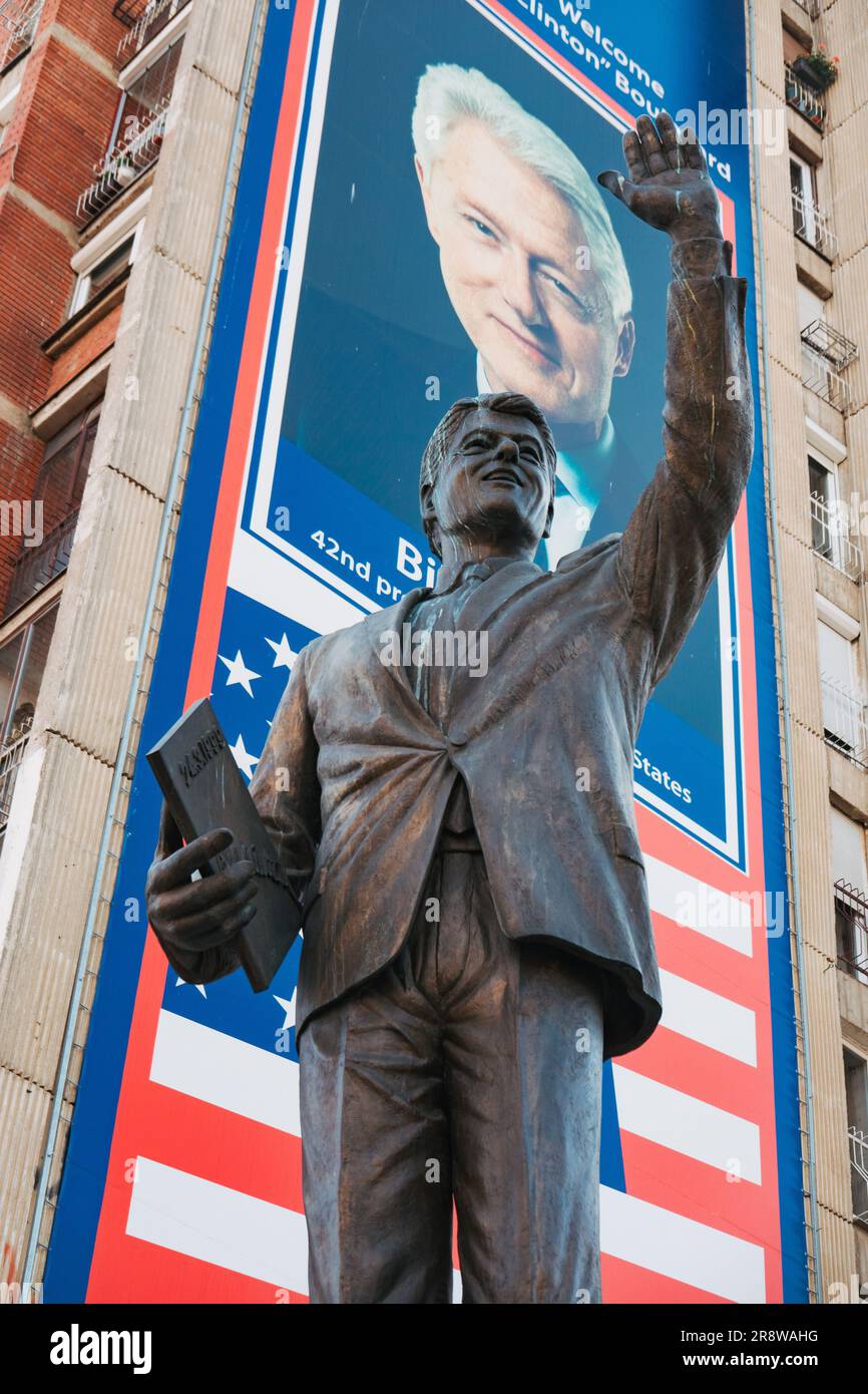 Una statua di U.S. Il presidente Bill Clinton eresse nel 2009 su un piedistallo davanti a un cartellone con bandiera americana a Pristina, in Kosovo Foto Stock
