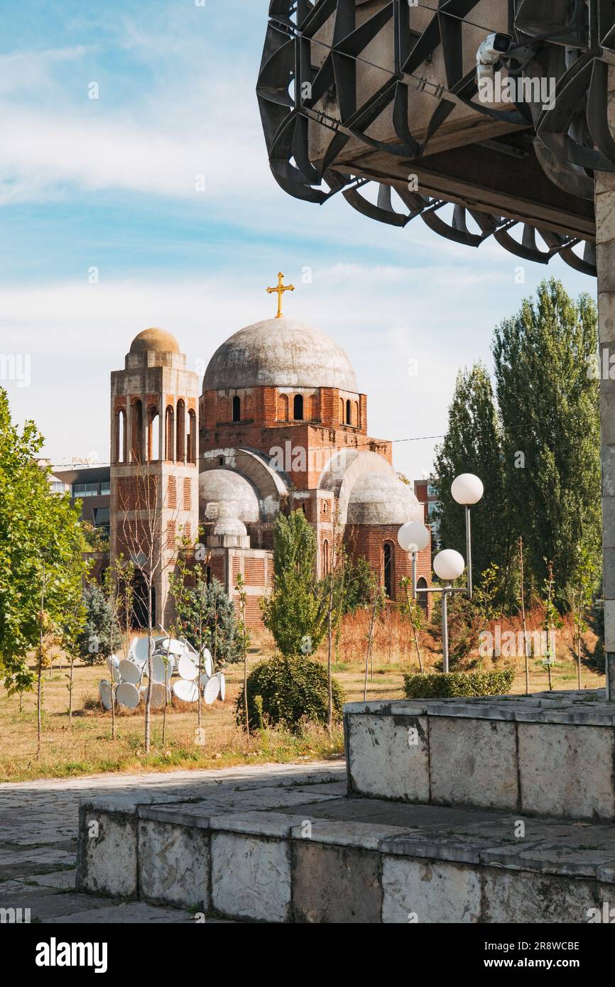 La Chiesa incompiuta di Cristo Salvatore, vista dai gradini della Biblioteca Nazionale del Kosovo, Pristina Foto Stock