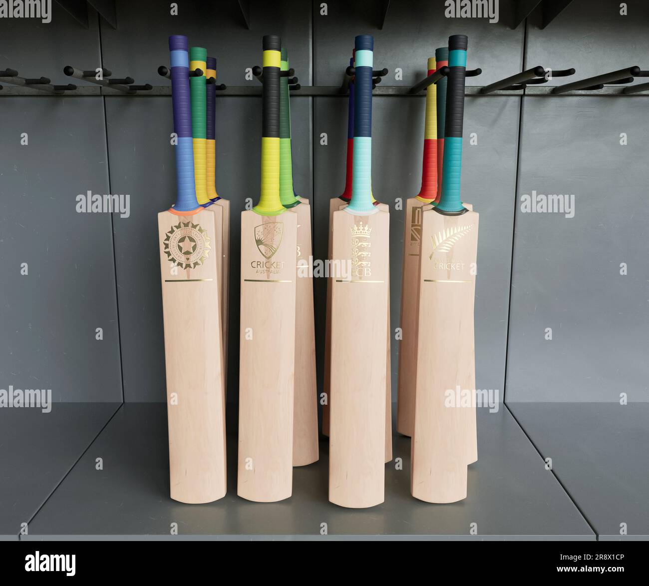 Una collezione di mazze da cricket impresse con loghi dorati dei paesi affiliati all'ICC, disposti su un espositore dello scaffale - 2 aprile 2023 Foto Stock