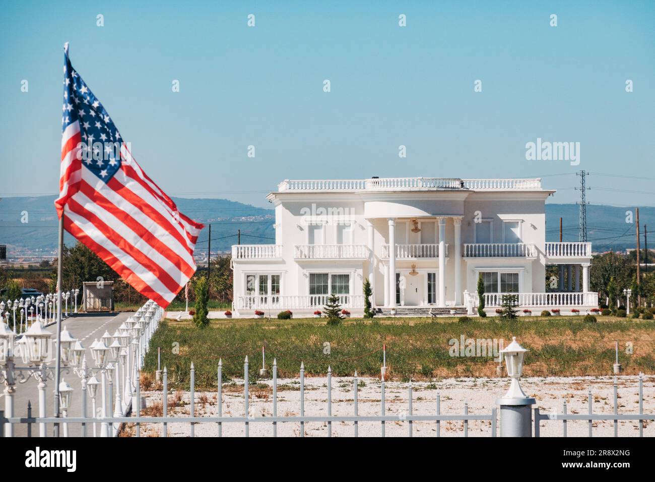 Una imitazione della Casa Bianca costruita a Llugaxhi, una città rurale del Kosovo/ una bandiera americana poggia sul cancello Foto Stock
