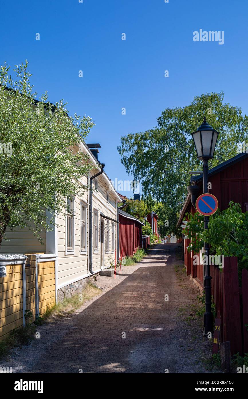 Vista pittoresca di una stretta strada sterrata e di vecchie case di legno nelle soleggiate giornate estive a Barckens udde, la città vecchia di Ekenäs o Tammisaari, Finlandia Foto Stock