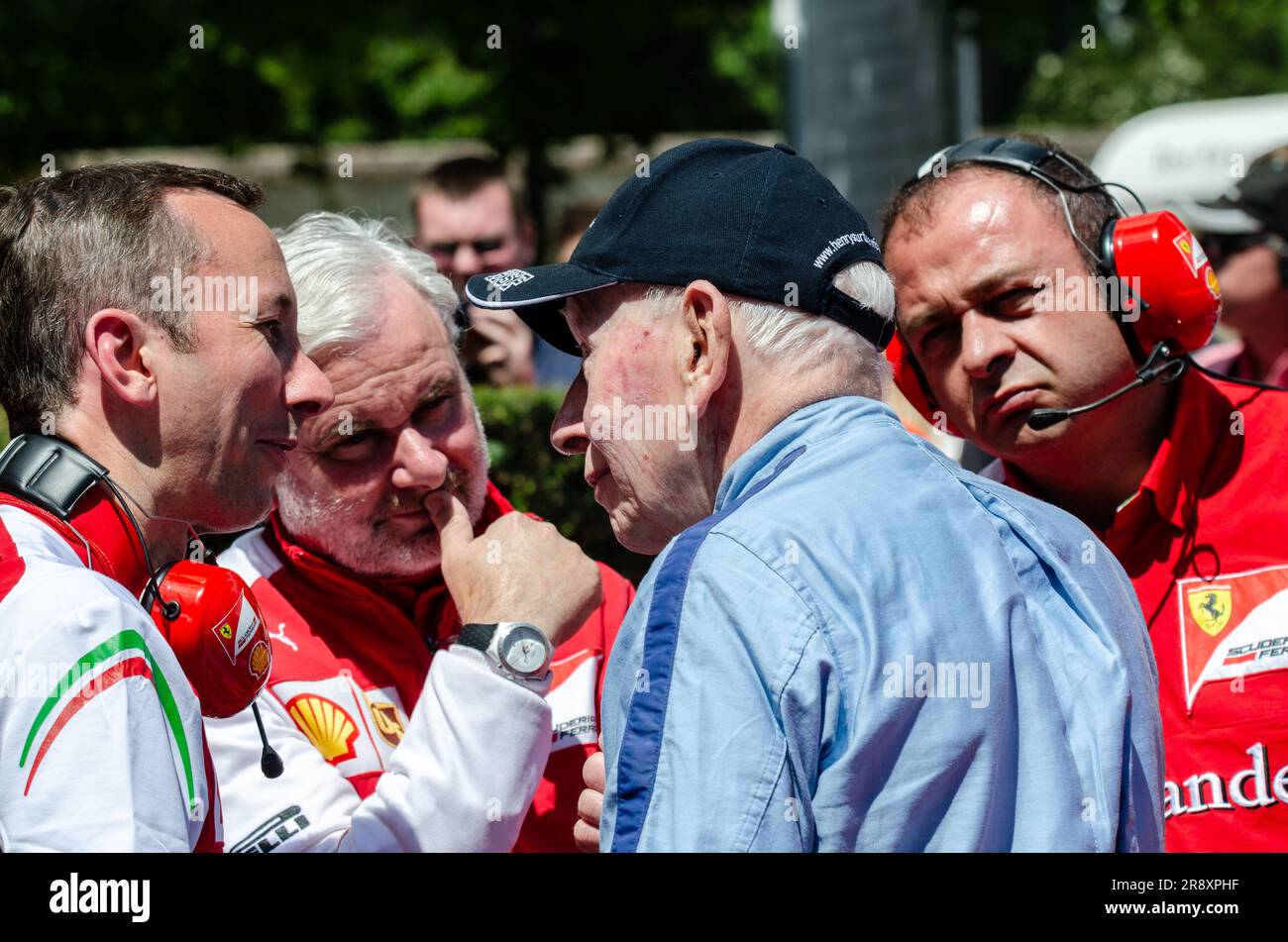 Il veterano John Surtees parla con l'attuale equipaggio Ferrari di Formula 1 al Goodwood Festival of Speed. Ingegneri che ascoltano attentamente Foto Stock