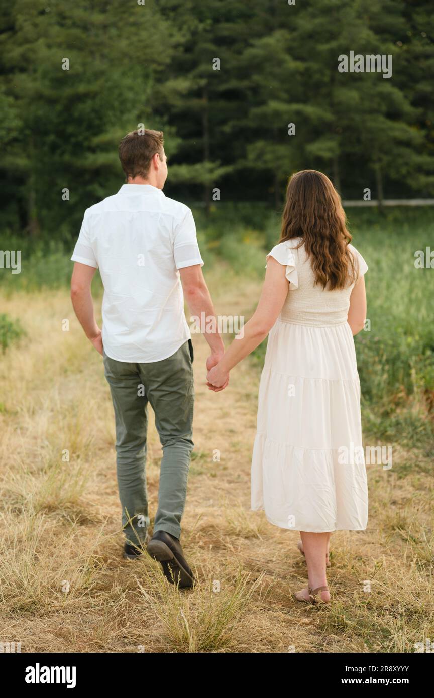 giovani coppie che si tengono per mano e camminano nel parco panoramico Foto Stock