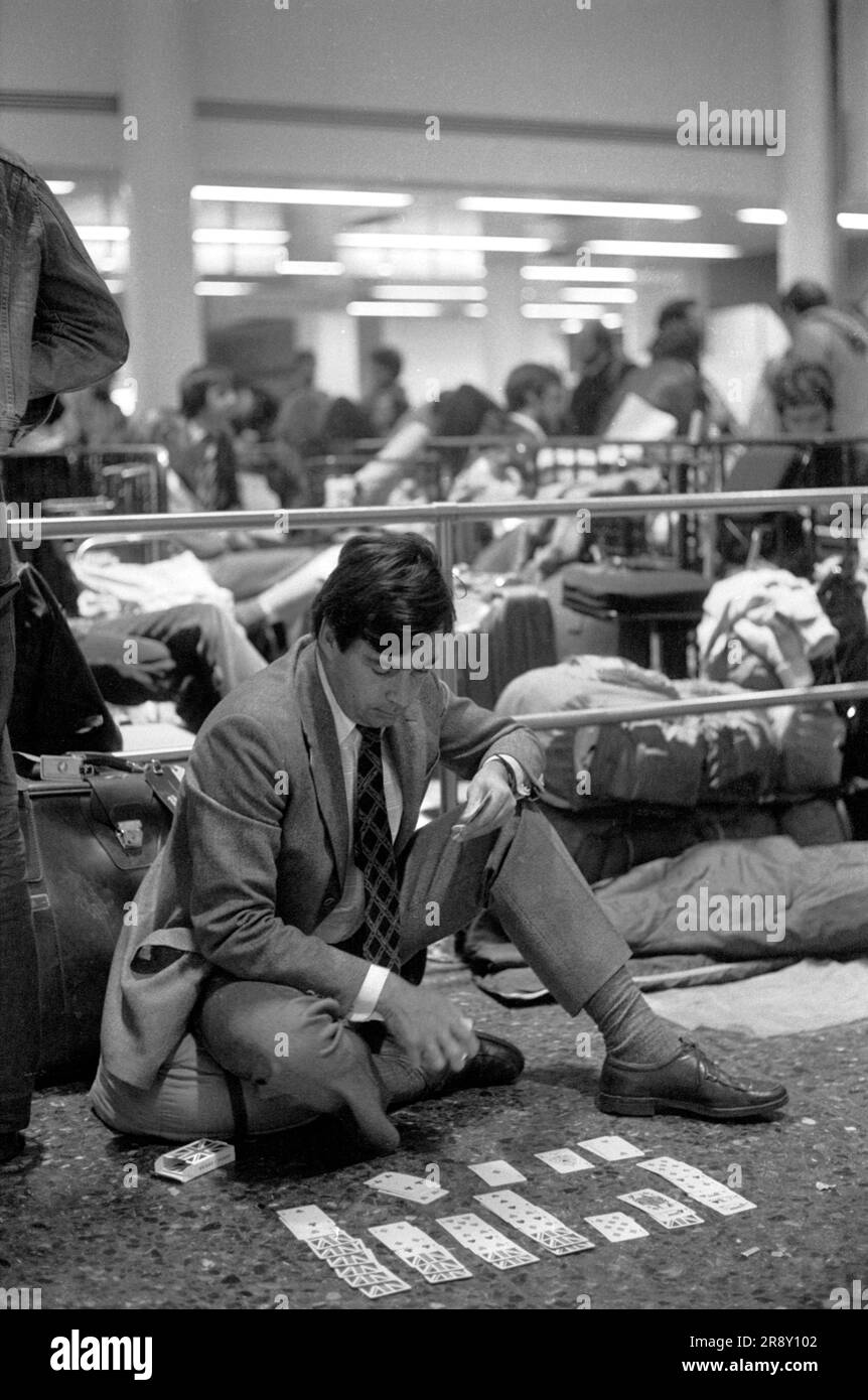 Uomo che gioca a carte chiamato Patience, mentre aspetta tutta la notte per poter acquistare un biglietto per il volo inaugurale dello Skytrain di Freddie Laker che si è svolto tra i tanti eventi il 26 settembre 1977. Si trattava di un servizio giornaliero economico e senza fronzoli tra Londra Gatwick e JFK a New York. 1970 UK HOMER SYKES Foto Stock