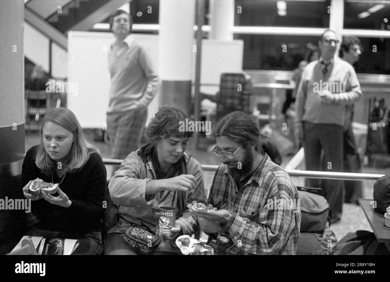 Fare uno spuntino, qualcosa da mangiare mentre si aspetta in coda. Gente che aspetta tutta la notte per comprare i biglietti per lo Skytrain inaugurale di Freddie Laker. Si trattava di un servizio giornaliero economico e senza fronzoli tra Londra Gatwick e JFK a New York il 26 settembre 1977. 1970 UK HOMER SYKES Foto Stock