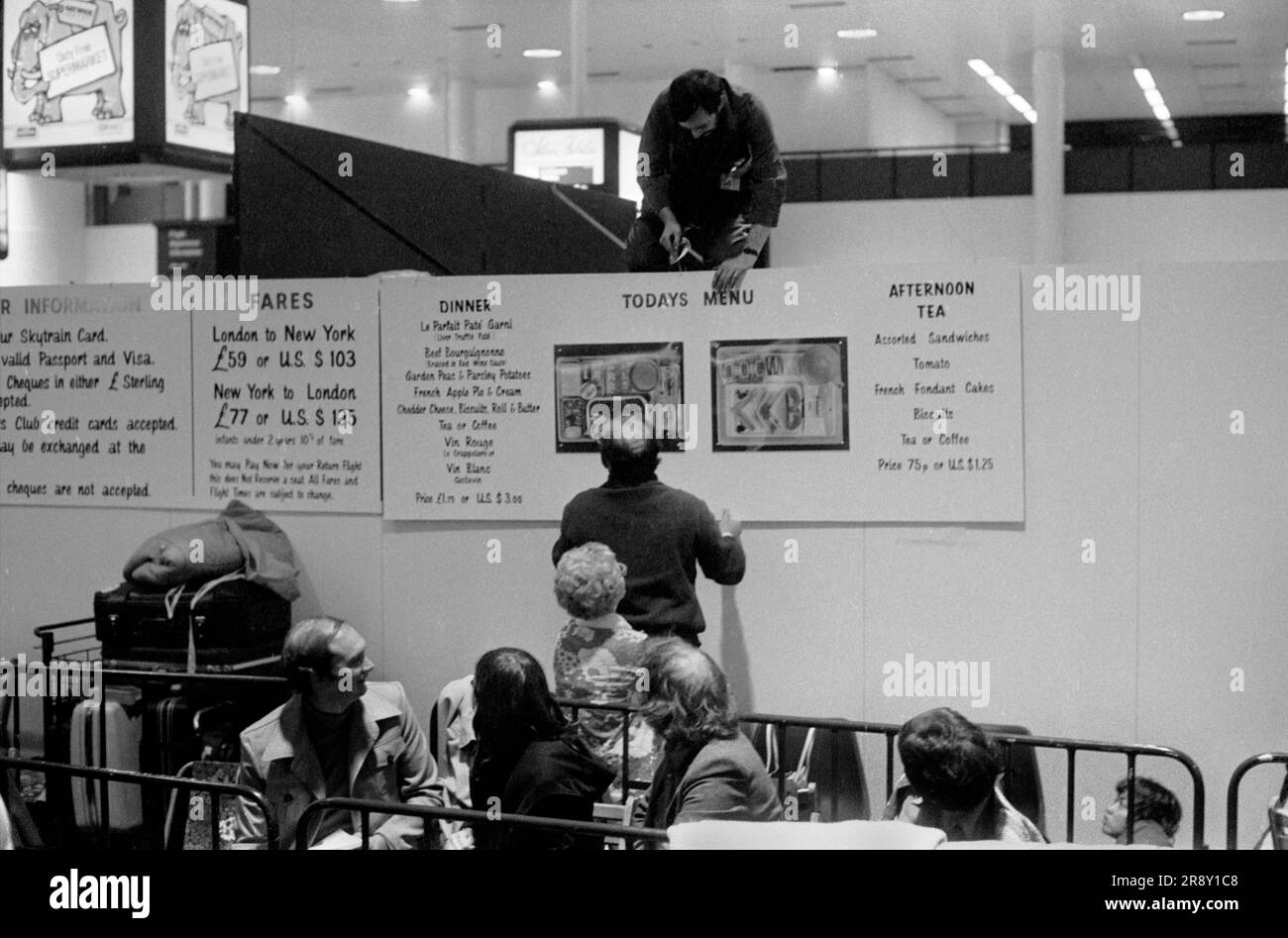 Preparatevi, operai che mettono la segnaletica mentre i clienti si allineano sotto in attesa di notte per il loro volo al mattino, Freddie Laker ha lanciato Skytrain, il volo inaugurale ha avuto luogo con grande entusiasmo il 26 settembre 1977. Si trattava di un servizio giornaliero economico e senza fronzoli tra Londra Gatwick e JFK a New York, negli anni '1970, UK HOMER SYKES Foto Stock