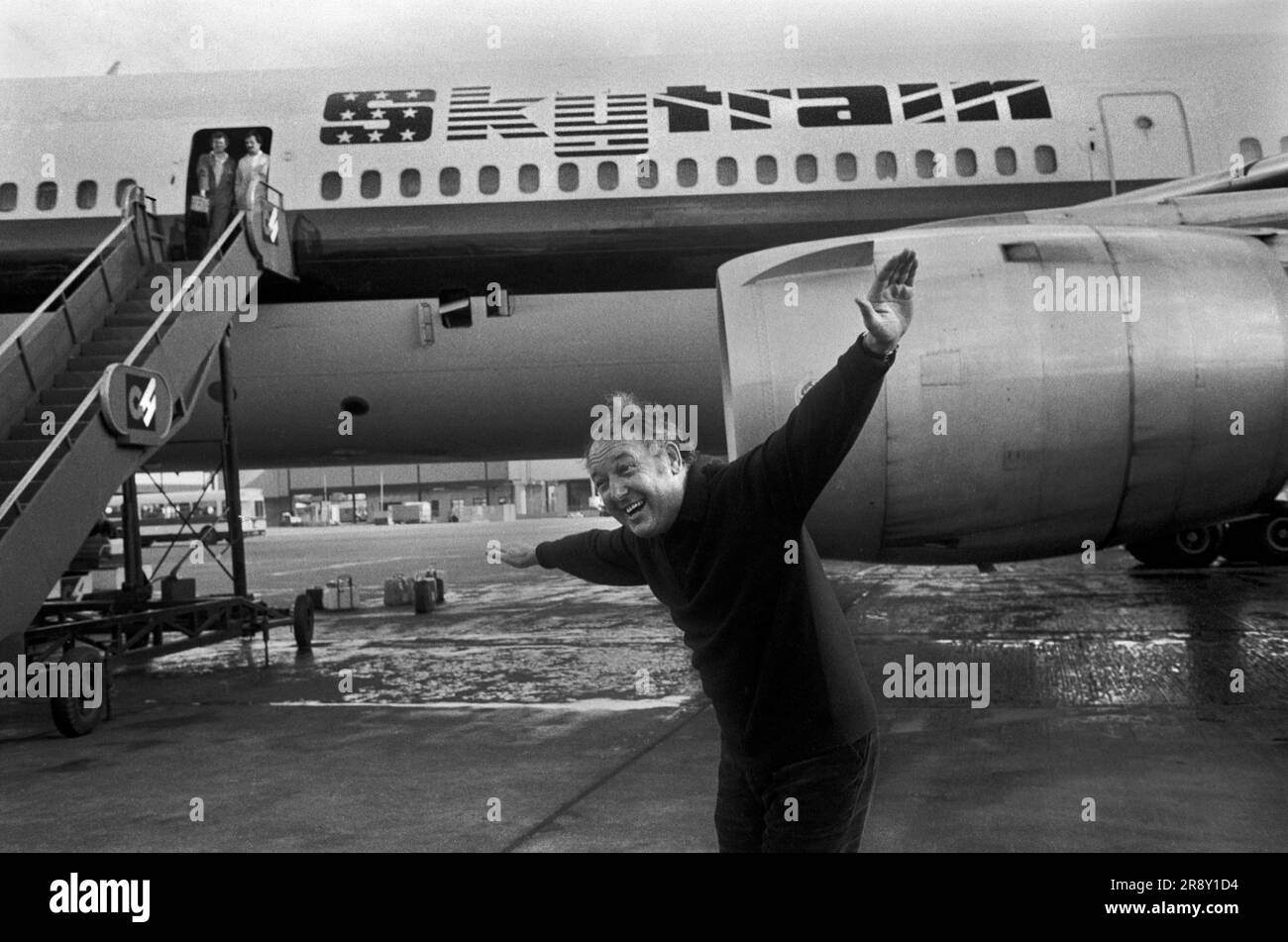 Freddie Laker ha lanciato Skytrain, il volo inaugurale ha avuto luogo il 26 settembre 1977. Questo era un servizio giornaliero senza fronzoli, economico e conveniente tra Londra Gatwick e JFK a New York. Freddie Laker incontra la stampa; la sua posa normale per i fotografi era con le braccia tese fingendo di essere uno dei suoi aerei. Foto Stock