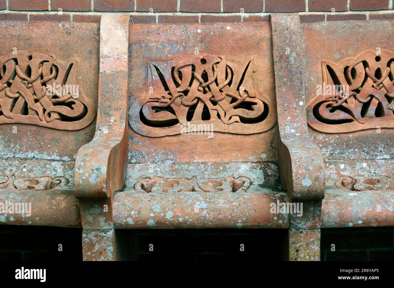 Posti a sedere all'esterno della Watts Memorial Chapel, Compton, Surrey. Con intreccio in terracotta ispirato al celtico/art nouveau (e una "W" per Watts?) Foto Stock