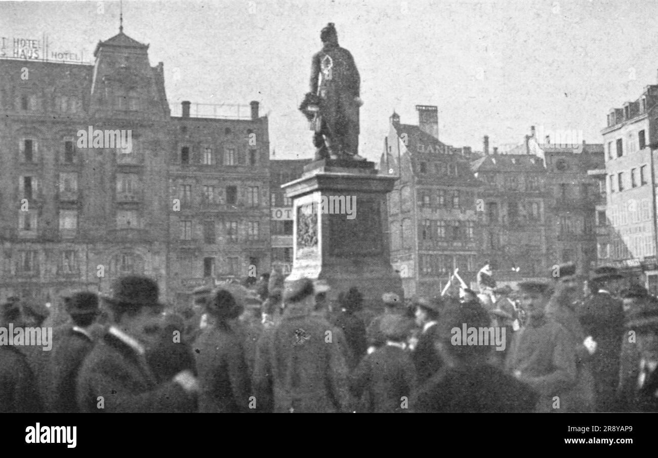 "Journees inoubliables a Strasbourg; le meme jour, Alsaciens et Lorrains se rassemblent autour de la statue de Kleber qu'ils parent de fleurs, en presence de soldats allemands", 1918. Da "l'album de la Guerre 1914-1919, volume 2" [l'Illustration, Paris, 1924]. Foto Stock