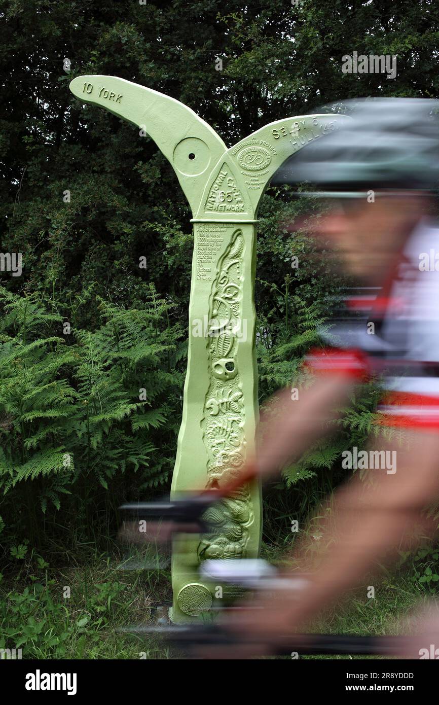 Un ciclista supera un cartello sulla pista ciclabile da York a Selby, lungo una linea ferroviaria in disuso. (Anche parte della pista ciclabile del sistema solare York.) Foto Stock