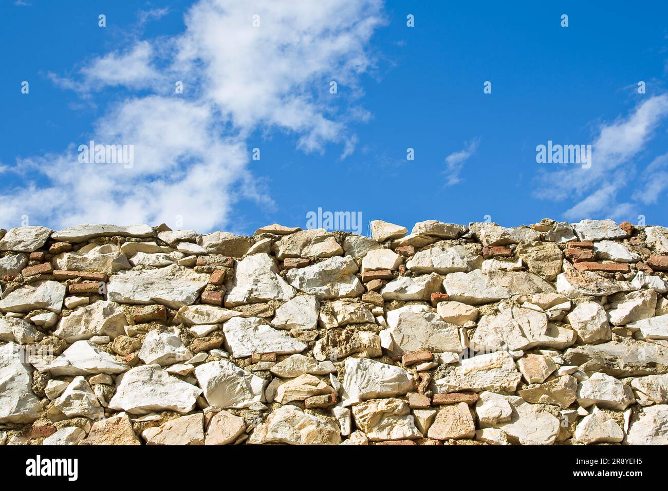Muro di pietra con grandi blocchi di pietra sullo sfondo del cielo. Foto Stock