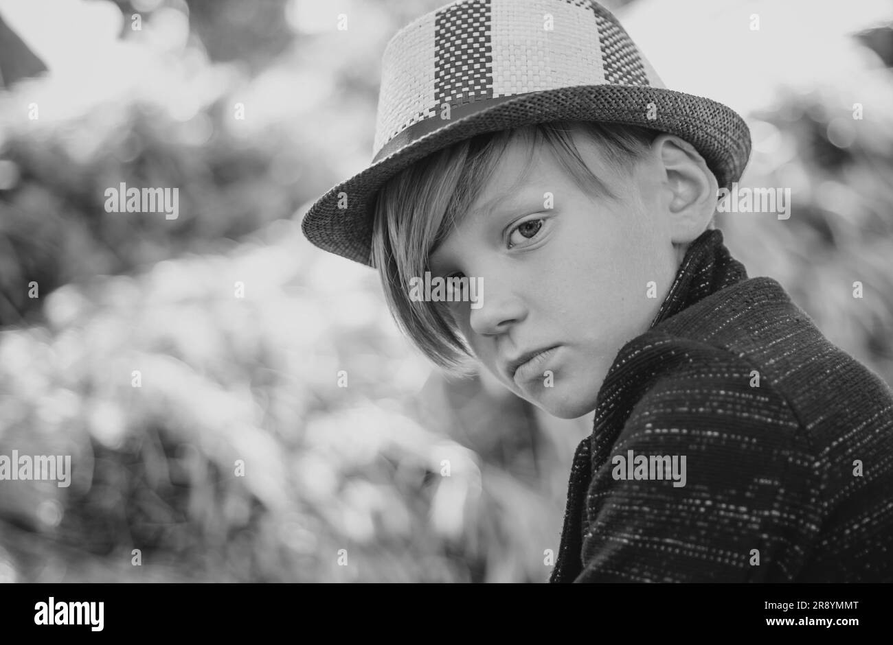 Carino bambino ragazzo su sfondo villaggio fattoria. Ragazzo che guarda la macchina fotografica. Primo piano verticale. Infanzia in fattoria. Buon tempo nel villaggio. Bambini Foto Stock