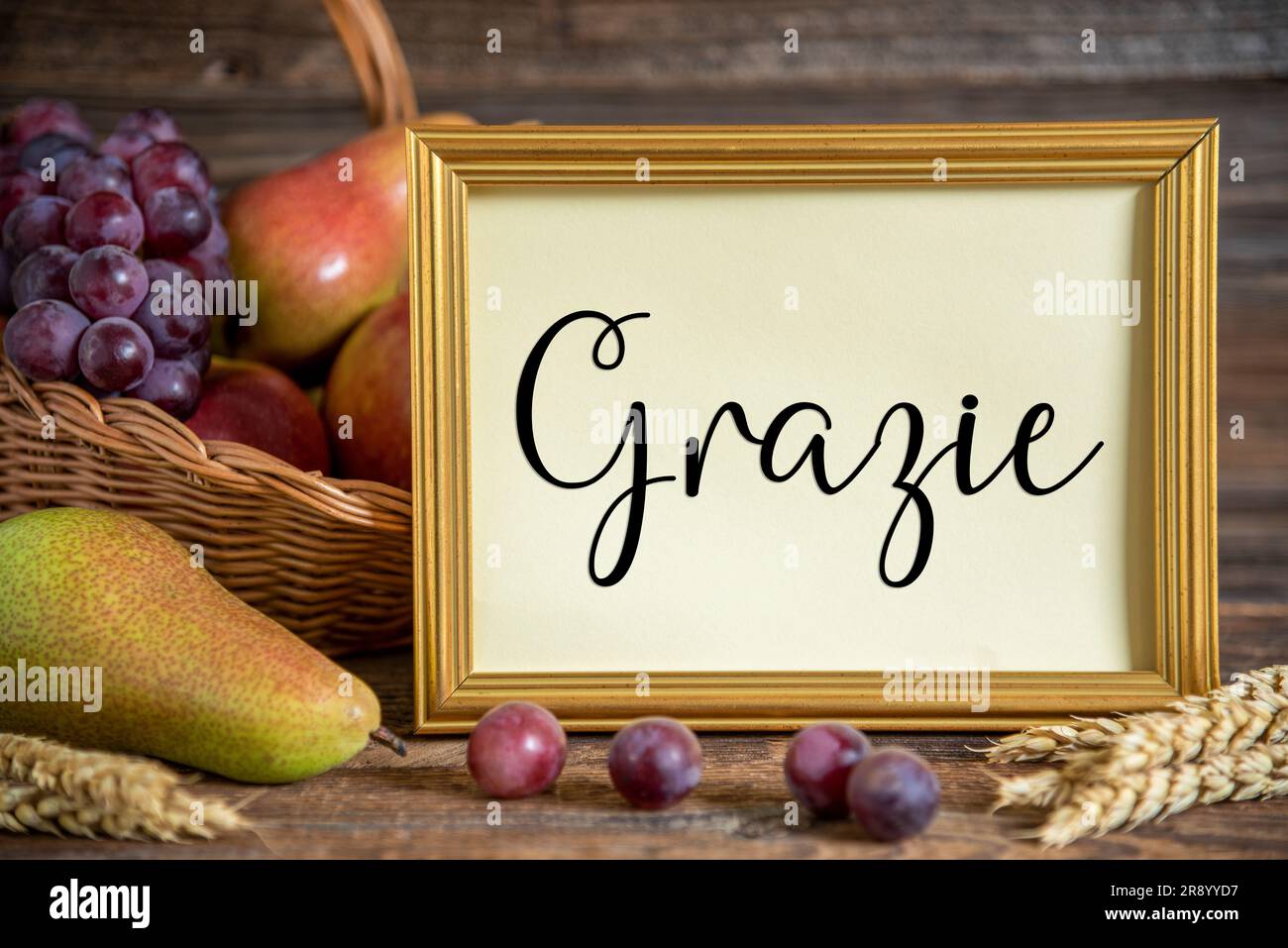 Decorazioni autunnali con pere, mele e uva, sfondo del Ringraziamento, stagione autunnale e italiano Text Grazie, che significa grazie in inglese Foto Stock