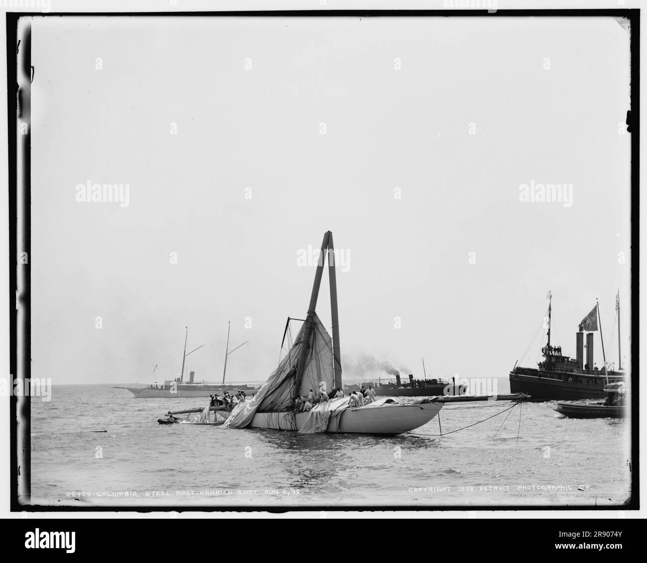 Columbia, albero in acciaio trasportato, 1899 agosto 2. Il Columbia era uno yacht da corsa statunitense progettato e costruito nel 1898-99 da Nathanael Herreshoff e dalla Herreshoff Manufacturing Company per i proprietari J. Pierpont Morgan e Edwin Dennison Morgan del New York Yacht Club. Nel 1899 è stata la difensore della decima gara della Coppa America contro il britannico Shamrock. La Columbia aveva un telaio in acciaio nichelato, uno scafo in bronzo e un albero in acciaio. Foto Stock