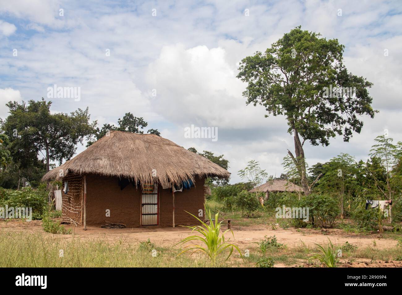 Tipica casa di fango rurale in un remoto villaggio in Africa con tetto di paglia, condizioni di vita molto essenziali e povere Foto Stock