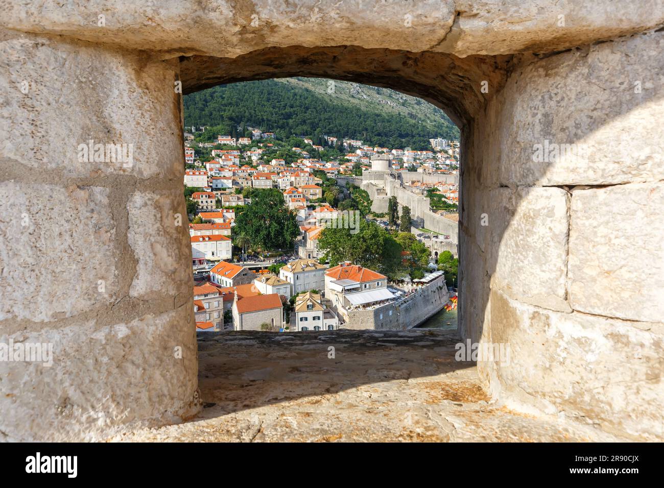 Dubrovnik, Croazia - 24 maggio 2023: Vista della città Vecchia attraverso un'apertura nella Muraglia della Fortezza di Dubrovnik, Croazia. Foto Stock