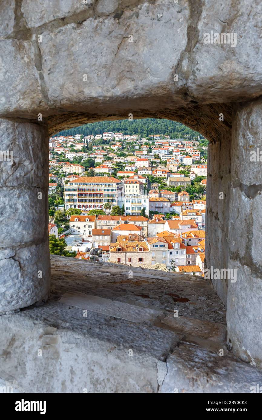Dubrovnik, Croazia - 24 maggio 2023: Vista della città Vecchia attraverso un'apertura nella Mura della Fortezza Hochformat a Dubrovnik, Croazia. Foto Stock