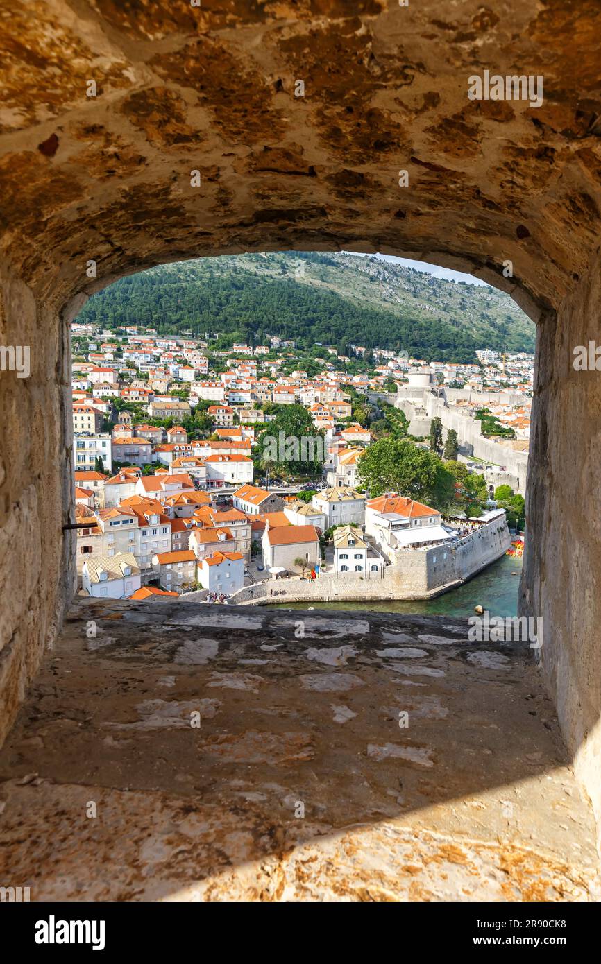 Dubrovnik, Croazia - 24 maggio 2023: Vista della città Vecchia attraverso un'apertura nella Mura della Fortezza Hochformat a Dubrovnik, Croazia. Foto Stock
