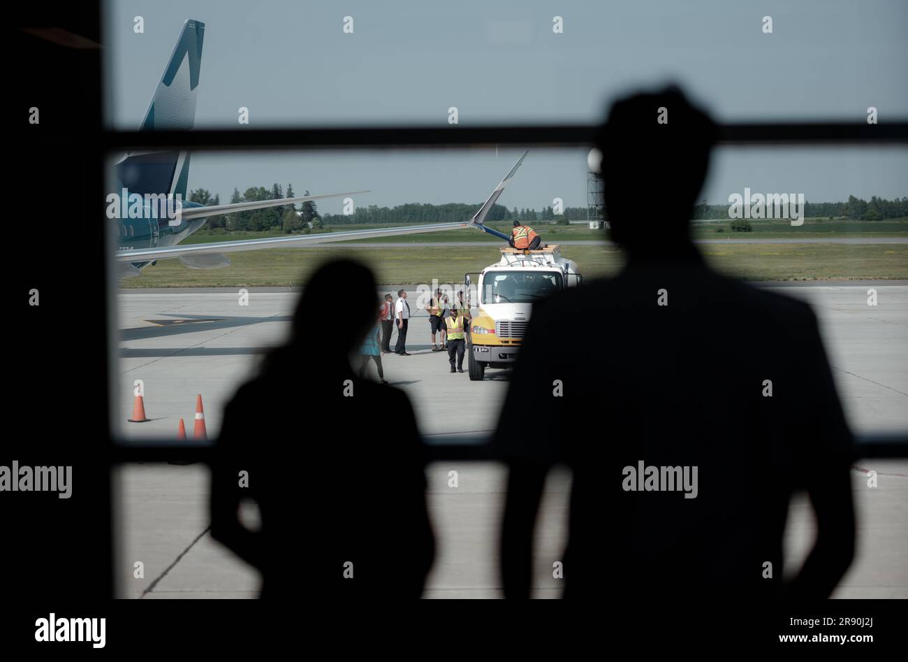 I dipendenti dell'equipaggio di terra e di volo ispezionano i danni ad un'ala Boeing 737-800 dopo aver colpito accidentalmente un camion parcheggiato per il rifornimento. Foto Stock