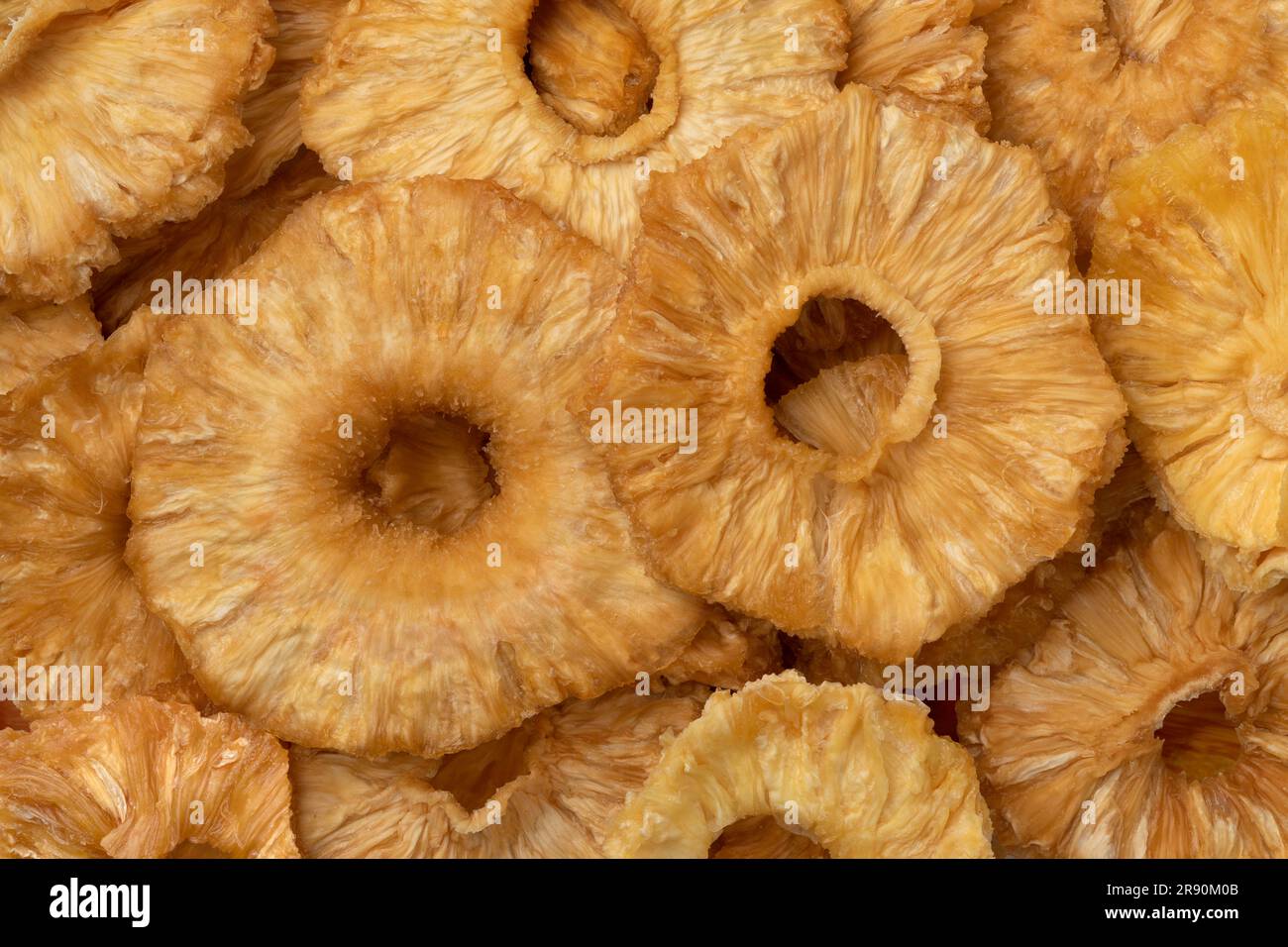 Le fette di ananas dolci secche chiudono l'intero fotogramma come sfondo Foto Stock