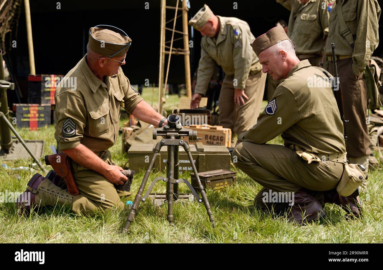 I membri di un gruppo di storia vivente della seconda guerra mondiale per la 29th Infantry Division puliscono un mortaio da 60 mm prima di prendere parte ad una rievocazione durante il primo giorno del Tankfest 2023 al Tank Museum di Bovington nel Dorset. Data foto: Venerdì 23 giugno 2023. Foto Stock