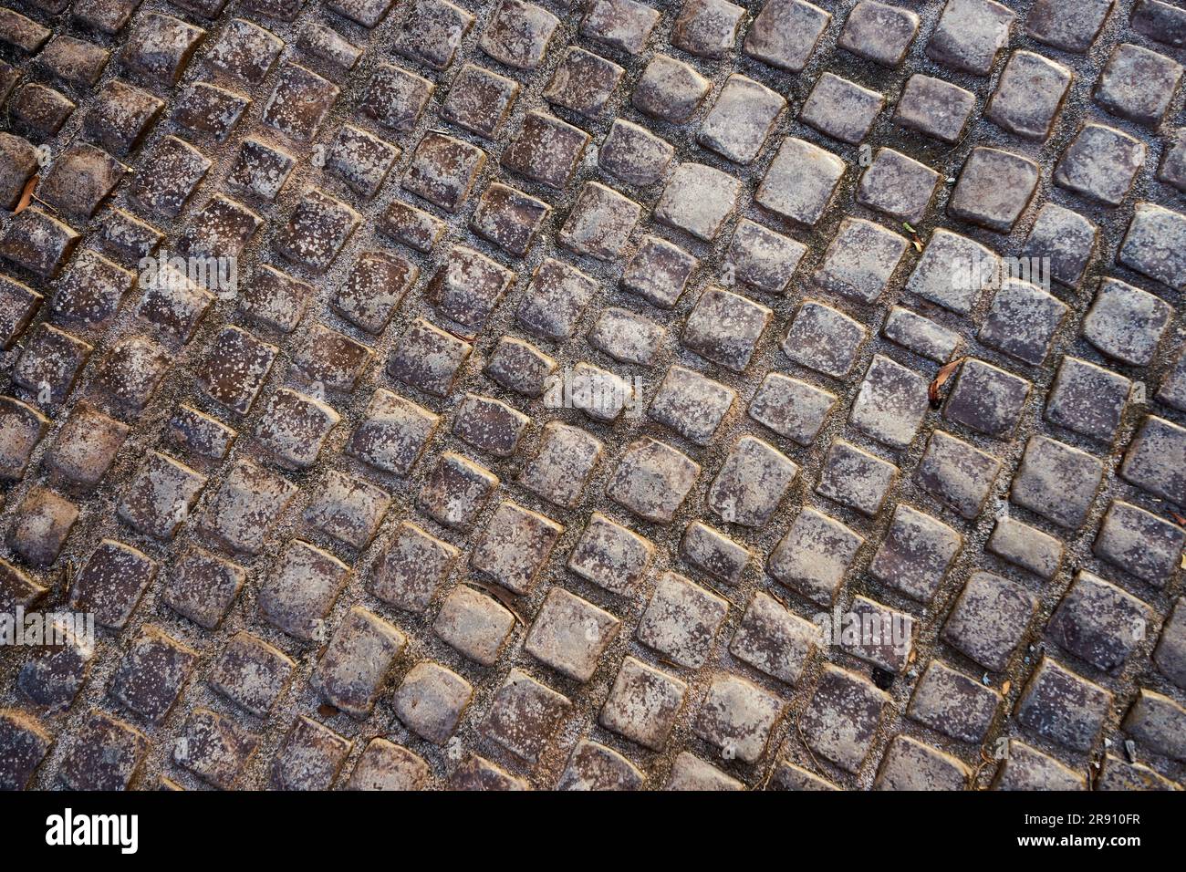 La texture della vecchia pavimentazione acciottolata Foto Stock