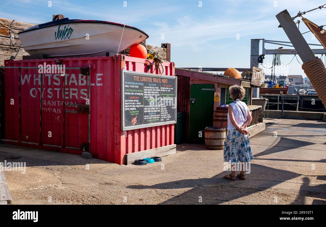 Whitstable North Kent , Inghilterra Regno Unito - donna che legge il menu al ristorante Lobster Shack a Whitstable Foto Stock