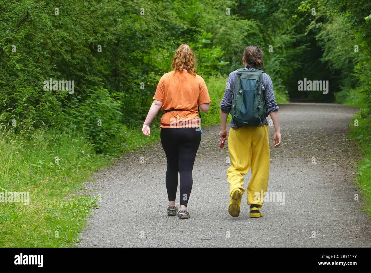 Una coppia in abiti colorati passeggia lungo il Sett Valley Trail nel Derbyshire Foto Stock