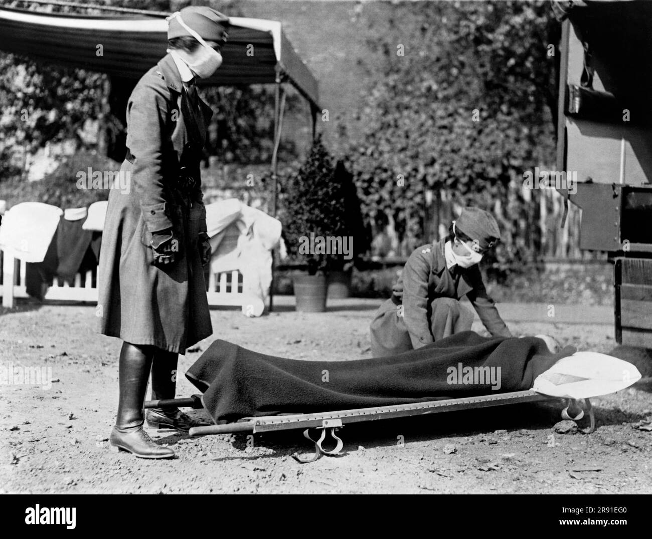 Washington, D.C.: 1918 due infermiere della Croce Rossa con una persona su una barella durante una manifestazione presso la stazione di emergenza della Croce Rossa durante la pandemia influenzale del 1918-1920. Foto Stock