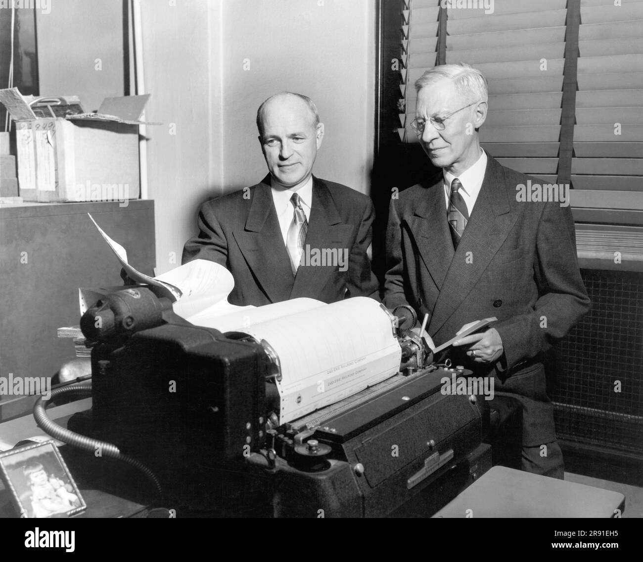 Cleveland, Ohio: c. 1954 due dirigenti che visualizzano schede tecniche stampate presso la Erie Railroad Company. Foto Stock