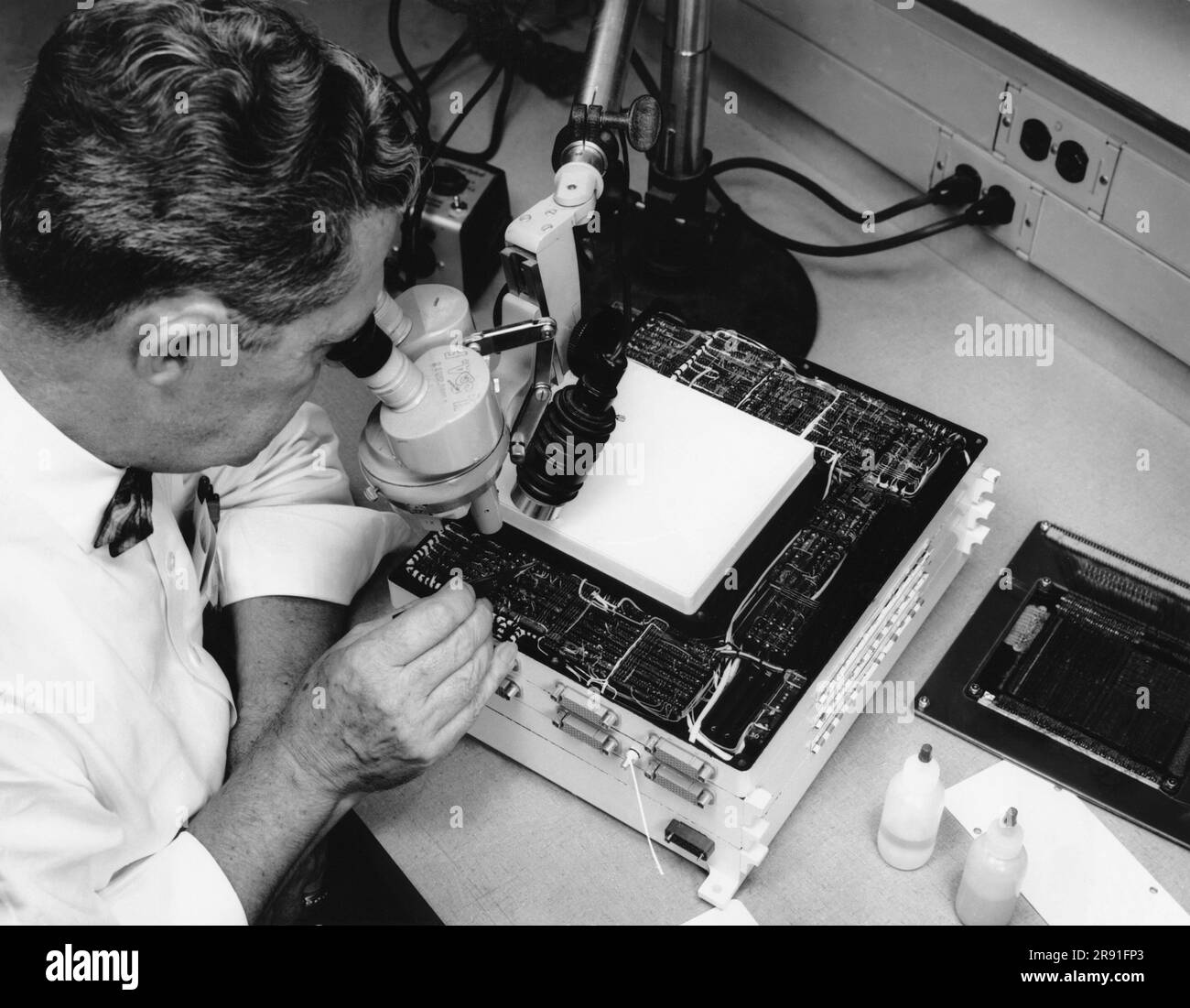 St.Petersburg, Florida: Novembre 1962 Un tecnico ispeziona un nuovo computer di guida aeronautica subminiatura sviluppato da Honeywell che può eseguire 3.000 aggiunte in una frazione di secondo. Foto Stock