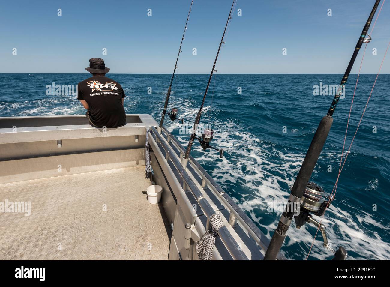Un uomo che pesca su un piccolo peschereccio al largo della costa di Broome, nell'Australia Occidentale Foto Stock