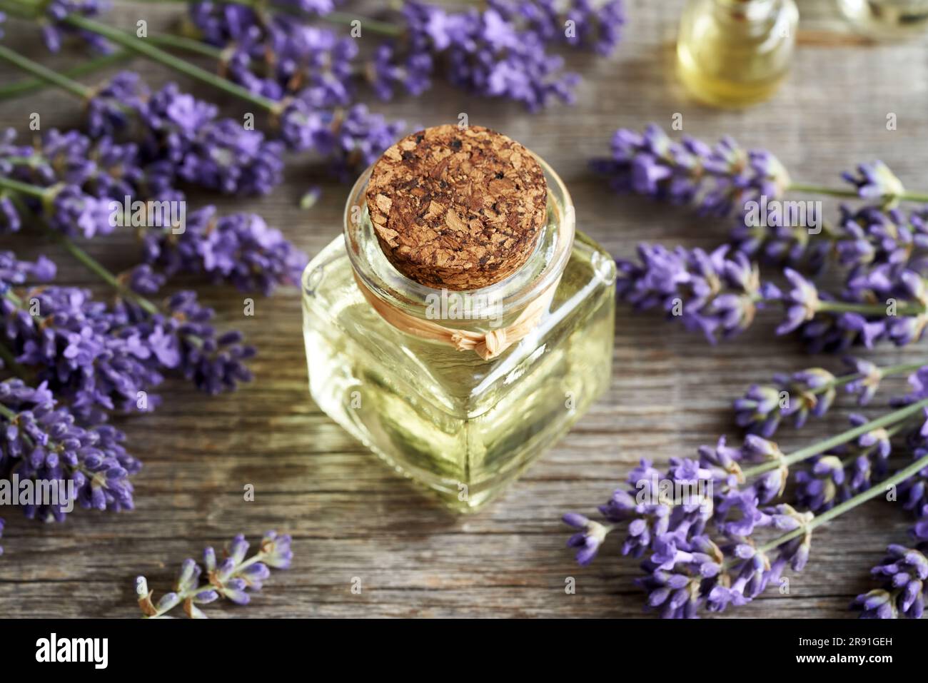 Olio essenziale di lavanda con piante fresche in fiore su un tavolo di  legno Foto stock - Alamy