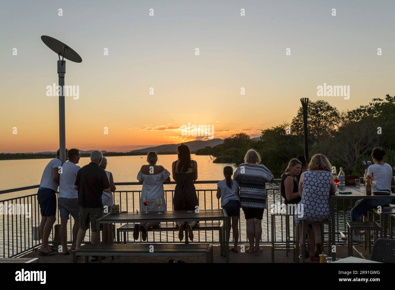 Persone che si godono un drink e si godono il tramonto sulla diga di Kununurra, Australia Occidentale Foto Stock