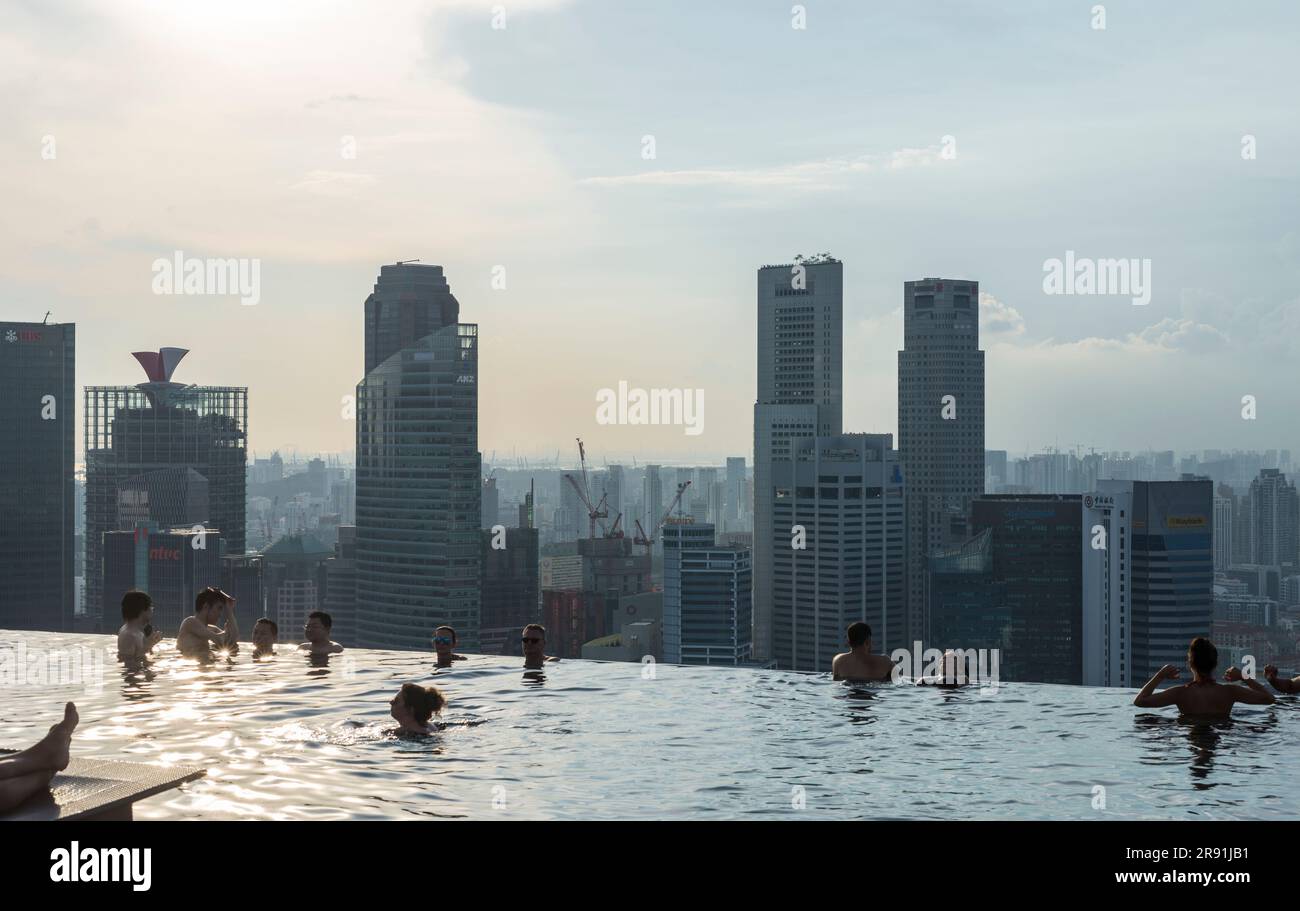 La gente si rilassa nella piscina sul tetto di un hotel di lusso affacciato sulla città di Singapore Foto Stock