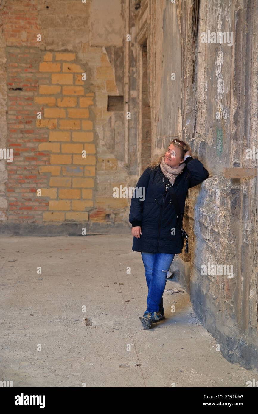 La foto mostra una ragazza in piedi nella sala di una vecchia villa in Ucraina. Foto Stock