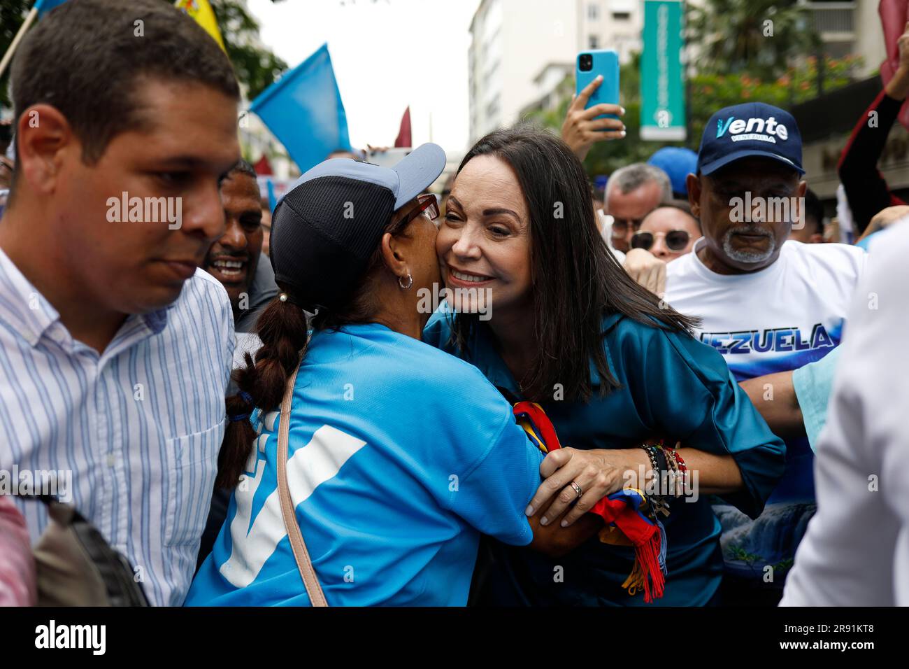 Caracas, Venezuela. 23 giugno 2023. Corina Machado (M) saluta una sostenitrice mentre arriva circondata da sostenitori a Plaza Altamira per l'annuncio della sua candidatura alle elezioni primarie in Venezuela. Il candidato dell'opposizione e leader del partito Vente Venezuela vuole correre contro il Chavismo nelle elezioni. Credito: Pedro Rances Mattey/dpa/Alamy Live News Foto Stock