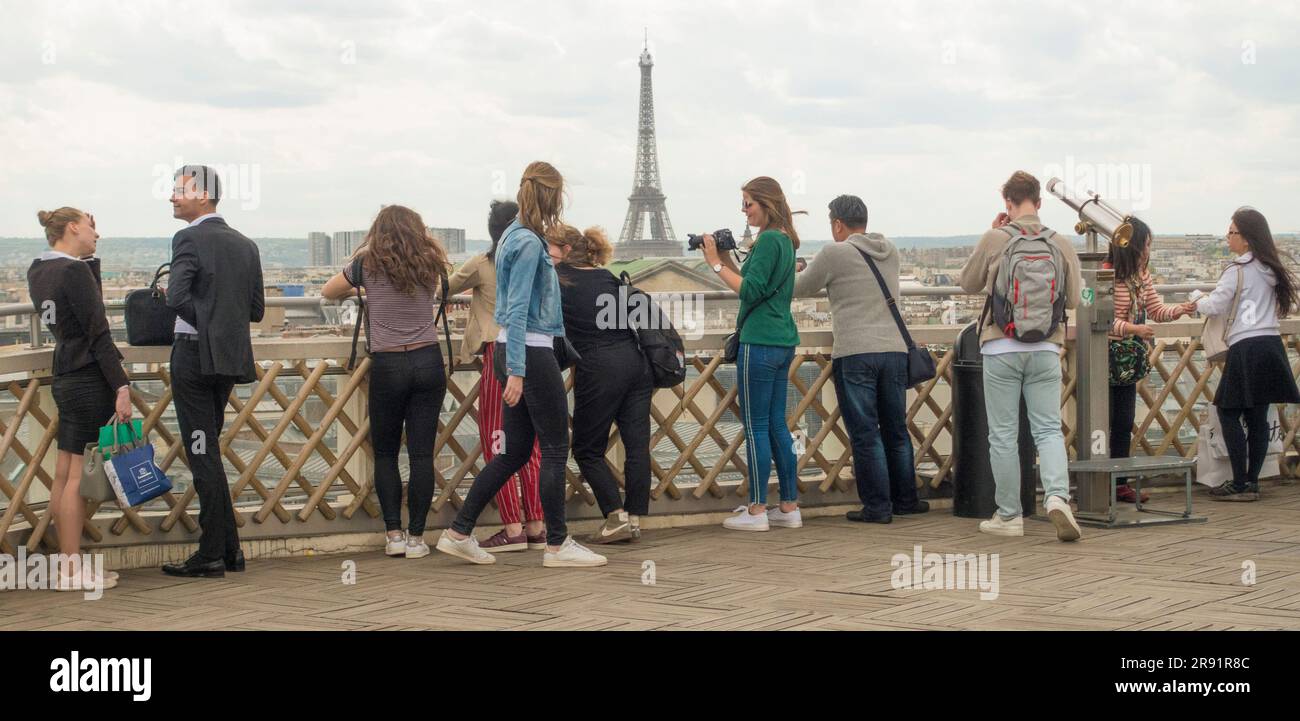 Le persone sulla terrazza sul tetto delle Galerias Lafayette ammirano lo skyline di Parigi con la Torre Eiffel Foto Stock