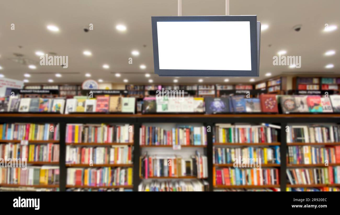 Un'invitante sala biblioteca con soffitto aperto illuminato da lampade e dotato di display digitale Foto Stock