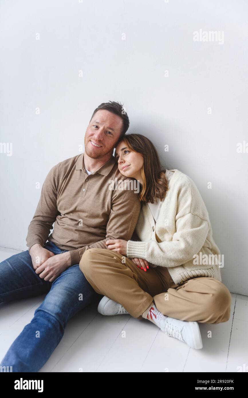 Uomo e donna seduti insieme sul pavimento Foto Stock