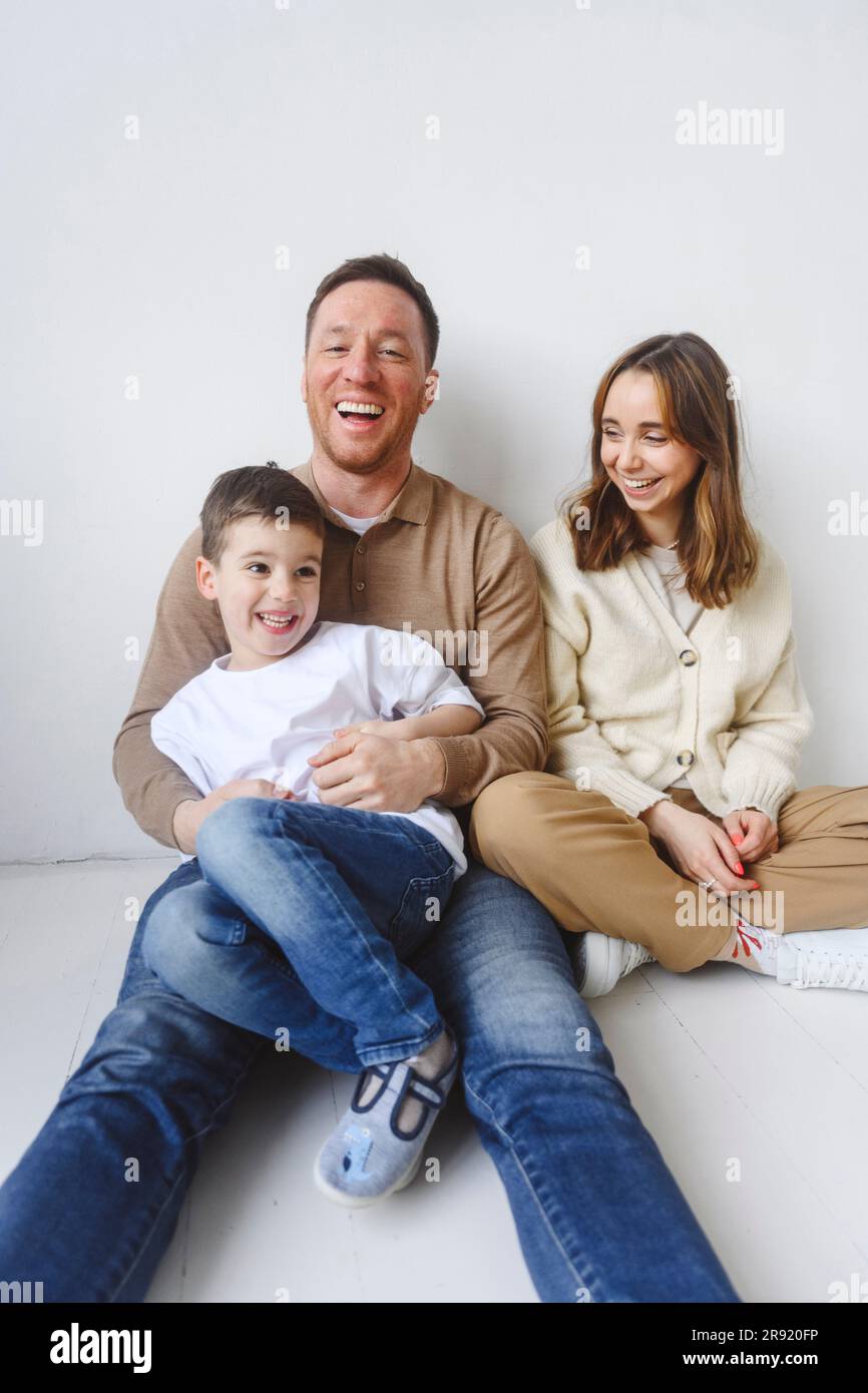 Famiglia con un figlio seduto sul pavimento Foto Stock