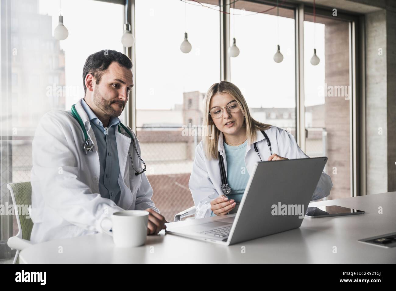 Colleghi medici che discutono sul portatile in ospedale Foto Stock