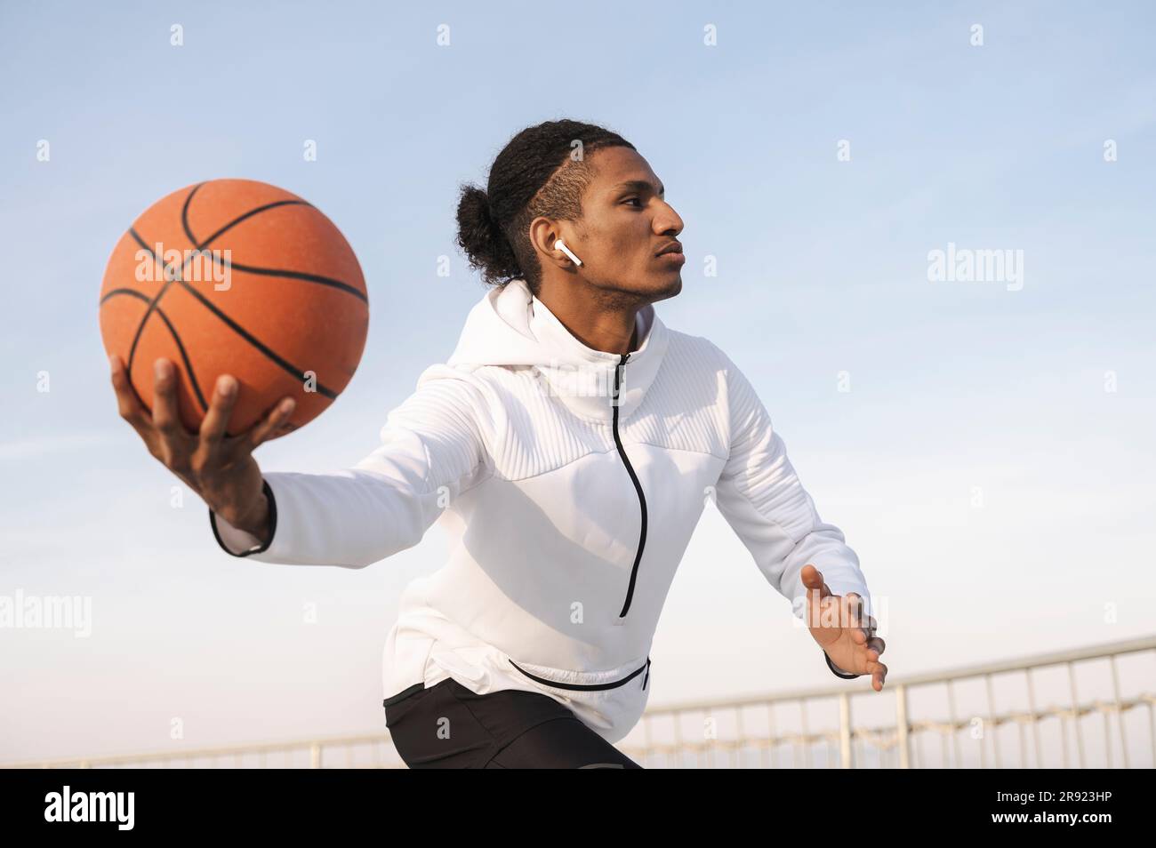 Giovane atleta che pratica il dribbling di pallacanestro nelle giornate di sole Foto Stock
